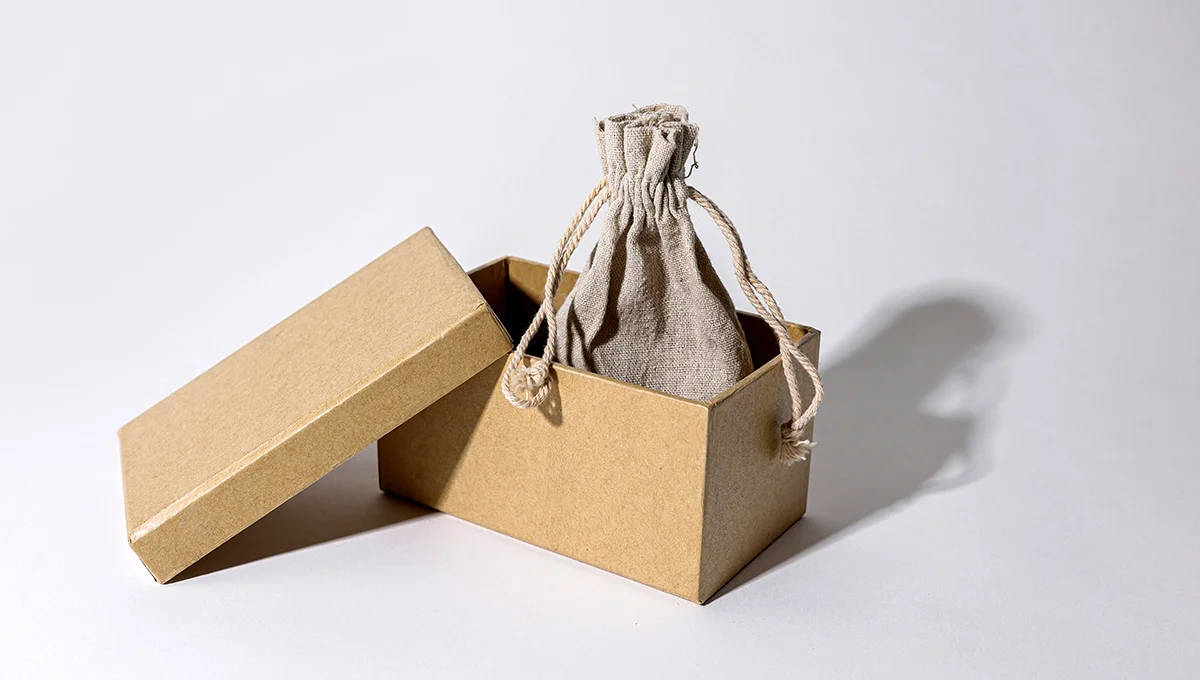A brown box containing a drawstring bag, showcasing a simple and practical packaging design.