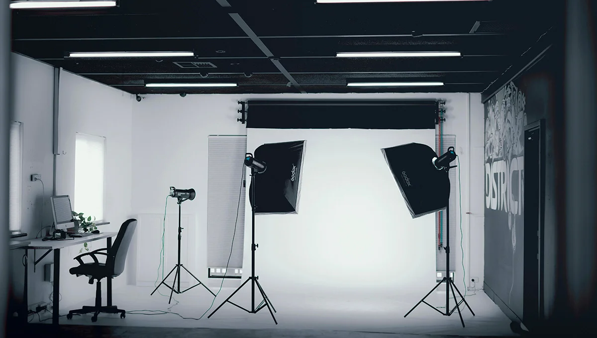 A photo studio featuring professional lighting and various photography equipment arranged for a photoshoot.
