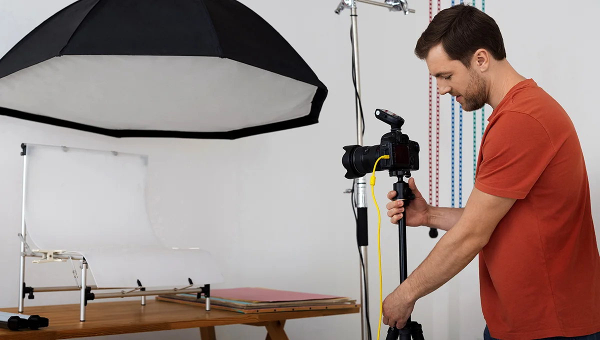A man prepares for 360 product photography, holding a camera and a white sheet for backdrop setup.