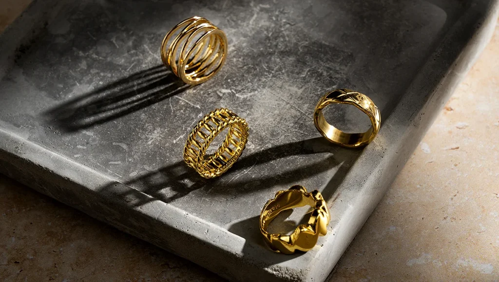 Three gold rings arranged neatly on a decorative tray.