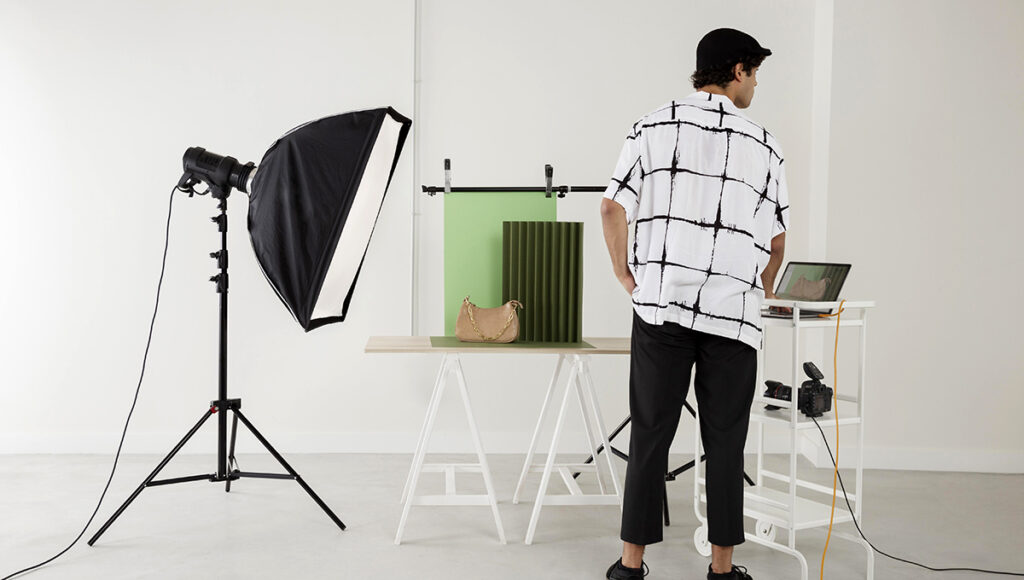 A man is positioned before a camera and laptop, ready for a commercial photography shoot.